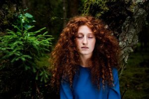 Frau mit geschlossenen Augen im Wald